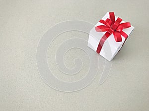 White gift box red ribbon bow on grey background , copy space.