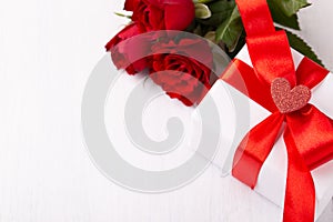 White gift box red ribbon and roses