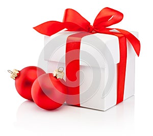 White gift box tied red ribbon bow and two Christmas bauble Isolated on white background