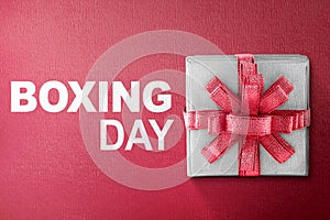 White gift box tied with red ribbon with Boxing Day text