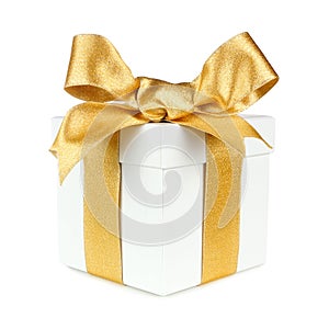 White gift box wrapped with gold ribbon and bow isolated on white