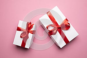 White Gift Boxes With Red Ribbons On Pink Background, Top View. Valentines Day Holiday Anniversary Birthday Idea