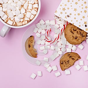 White Gift Shopping Paper Bags Full of Marshmellow aSweet Cookies and Candy Cane on Pink White Cup of Cocoa Background Shopping or