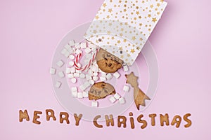 White Gift Shopping Paper Bags Full of Marshmellow and Sweet Cookies and Candy Cane on Pink Background Shopping or Food Merry