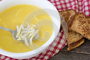 White glass bowl of noodle soup with a sandwhich