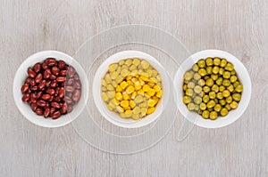 White glass bowls with green peas, beans and sweet corn