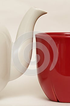 White glazed faience tea pot and red cup photo