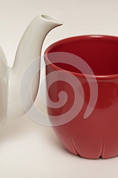 White glazed faience tea pot and red cup photo