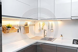 White gloss kitchen interior with worktop lighting