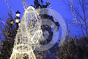 White glowing lights garlands in the shape of a horse`s head of Russian Troika on the street.