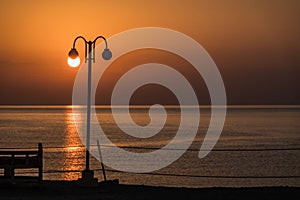 white glowing sun on a lantern during sunrise at the red sea