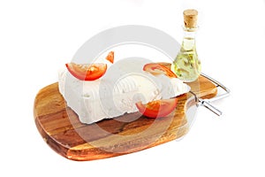 White goat cheese on wooden and sliced tomatoes