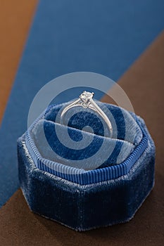 White gold engagement ring with diamond in blue vintage velvet ring box