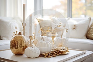 White and gold home autumn decoration. Flowers stand in a vase on the table next to the luxury sofa. Elegant home decor