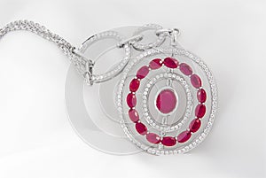 White gold pendant with diamonds and rubies on soft white background