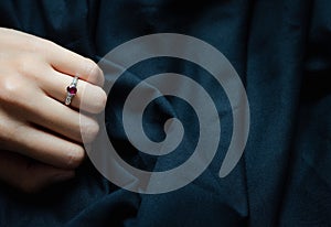 White gold with ruby and diamond ring isolated on black fabric background