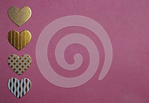 White and golden heart-shaped decorations on pink background. Valentine`s Day concept. Greeting card.