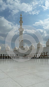White and golden Minarete of the Sheikh Zayed Mosque in the blue sky photo