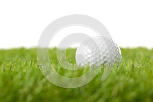 White golf ball on green grass lawn with copy space, isolated on white background