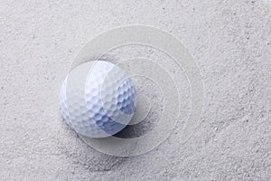 White golf ball in sand trap