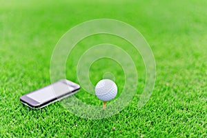 White golf ball on tee with mobile