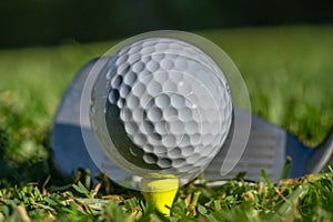 White golf ball teed up on a yellow tee