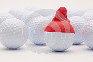 White golf balls with funny cap on the white background.