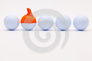 White golf balls with funny cap on the white background.