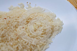 White grain rice on a white plate.