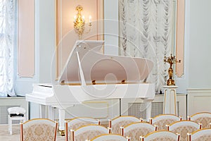 White grand piano on concert hall