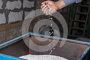 White granules of recycled plastic trash in the hand