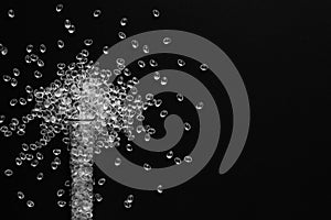 White granules of rubber and polypropylene on a black background in a chemical test tube. Plastics and polymers industry.