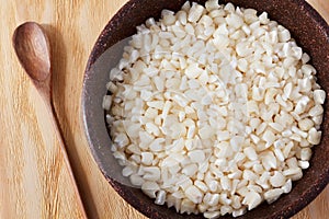 White grated corn kernels in brown bowl