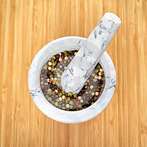 White and gray marble mortar and pestle with exotic pepper.