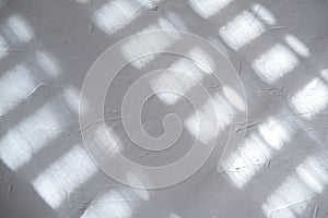 White gray plastered wall background. White concrete background close up. Abrasive white cement background in the rays of the sun