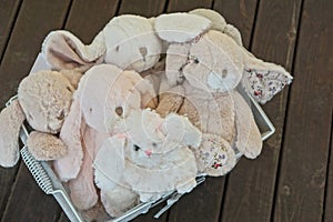 White gray plush toys hares and a dog