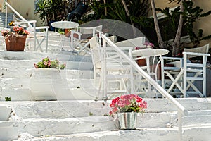 White Greek stairs with tables and chairs. Typical Greek street