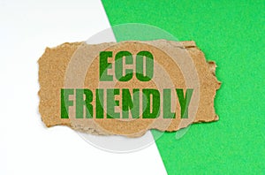 On a white-green background lies a piece of cardboard with the inscription - ECO FRIENDLY