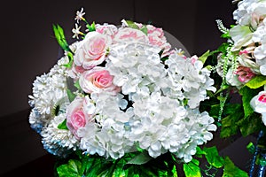 White and green color based artificial plastic flowers a bouquet.