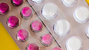 White, green, pink, orange capsules pill spilled out from white plastic bottle container. Global healthcare concept. Antibiotics d