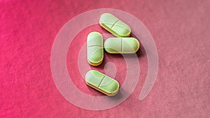 White, green, pink, orange capsules pill spilled out from white plastic bottle container. Global healthcare concept. Antibiotics d
