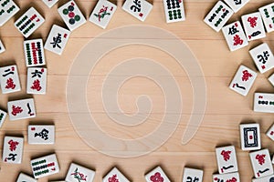 White-green tiles for mahjong on a background of light brown wood. Empty space in the center