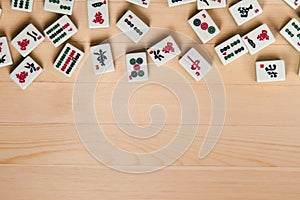 White-green tiles for mahjong on a brown wooden background. Empty space from below