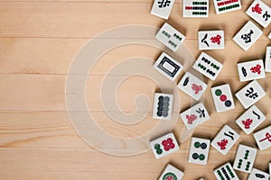 White-green tiles for mahjong on a brown wooden background. Empty space on the left