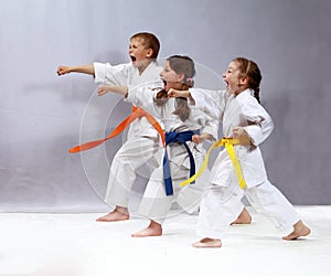 On the white and grey background three athletes in the racks are beating punches