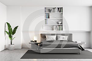 White and grey bedroom, bed with linens and bookshelf