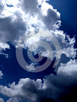 White grey and black, fluffy clouds in blue sky. Blue sky with clouds, White clouds on blue sky background close up