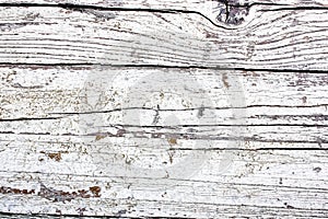 White and greyish painted cracked and peeling wooden wall board as texture background