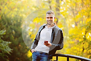 White guy using a mobile phone in a park