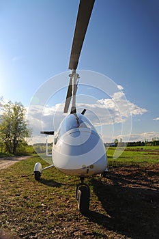 White gyroplane parked on the private airfield